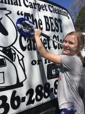 Technician from Cardinal Carpet & Air Duct Cleaning Co. performing professional carpet cleaning in a St. Louis home