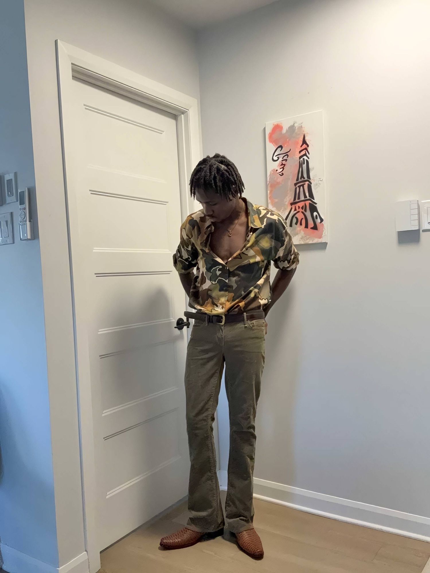 Roody Jay wearing a blue denim outfit, white T-shirt, decorative belt and camel-colored boots, showcasing his personal urban fashion style.
