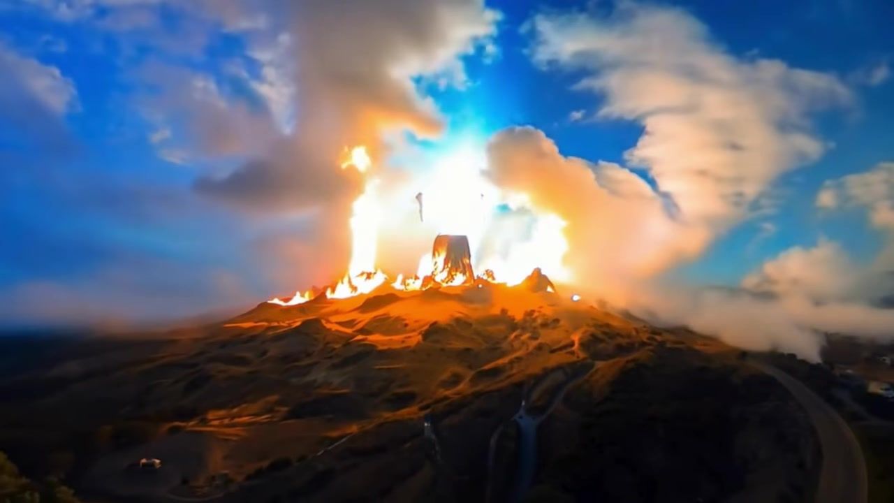 Fire on a rock under a blue sky, frame from the Tattoo de fenix music video